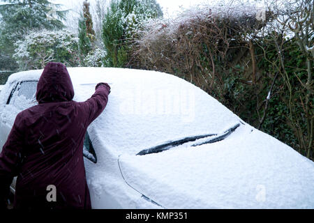 Frau clearing Schnee von einem Auto Stockfoto