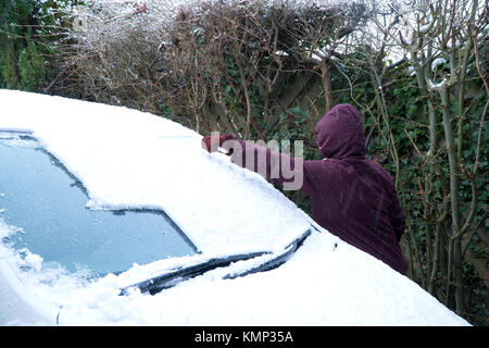 Frau clearing Schnee von einem Auto Stockfoto