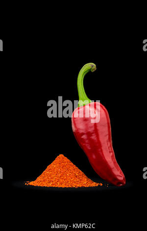 Eine Espelette Chili und Pulver (Capsicum annuum) fotografiert auf einem schwarzen Hintergrund. Piment d'Espelette. Red Chili. Stockfoto