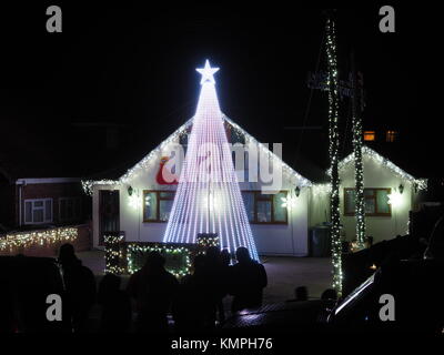 Warden Bay, Kent, Großbritannien. 8 Dez, 2017. Ein Haus in Warden Bucht setzt auf eine beeindruckende Weihnachtsbeleuchtung Anzeige mit einem Weihnachtsbaum größer als das Haus von der Beleuchtung, die eine Reihe von Computer-gesteuerte Muster gebildet. Jeden Freitag im Dezember vor Weihnachten eine kurze Anzeige auf ist für Einheimische um 19.00 Uhr, mit den Lichtern zu Musik eingestellt. Heute Abend sogar auf den außergewöhnlich kalten Abend, rund 50 Personen kam heraus zu beobachten. Die Anzeige ist von Daniel und Kelly Arnott mit Spenden aufgebracht für Nächstenliebe organisiert. Credit: James Bell/Alamy Leben Nachrichten. Stockfoto