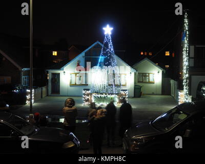 Warden Bay, Kent, Großbritannien. 8 Dez, 2017. Ein Haus in Warden Bucht setzt auf eine beeindruckende Weihnachtsbeleuchtung Anzeige mit einem Weihnachtsbaum größer als das Haus von der Beleuchtung, die eine Reihe von Computer-gesteuerte Muster gebildet. Jeden Freitag im Dezember vor Weihnachten eine kurze Anzeige auf ist für Einheimische um 19.00 Uhr, mit den Lichtern zu Musik eingestellt. Heute Abend sogar auf den außergewöhnlich kalten Abend, rund 50 Personen kam heraus zu beobachten. Die Anzeige ist von Daniel und Kelly Arnott mit Spenden aufgebracht für Nächstenliebe organisiert. Credit: James Bell/Alamy Leben Nachrichten. Stockfoto