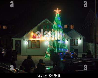 Warden Bay, Kent, Großbritannien. 8 Dez, 2017. Ein Haus in Warden Bucht setzt auf eine beeindruckende Weihnachtsbeleuchtung Anzeige mit einem Weihnachtsbaum größer als das Haus von der Beleuchtung, die eine Reihe von Computer-gesteuerte Muster gebildet. Jeden Freitag im Dezember vor Weihnachten eine kurze Anzeige auf ist für Einheimische um 19.00 Uhr, mit den Lichtern zu Musik eingestellt. Heute Abend sogar auf den außergewöhnlich kalten Abend, rund 50 Personen kam heraus zu beobachten. Die Anzeige ist von Daniel und Kelly Arnott mit Spenden aufgebracht für Nächstenliebe organisiert. Credit: James Bell/Alamy Leben Nachrichten. Stockfoto