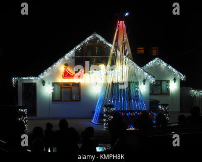 Warden Bay, Kent, Großbritannien. 8 Dez, 2017. Ein Haus in Warden Bucht setzt auf eine beeindruckende Weihnachtsbeleuchtung Anzeige mit einem Weihnachtsbaum größer als das Haus von der Beleuchtung, die eine Reihe von Computer-gesteuerte Muster gebildet. Jeden Freitag im Dezember vor Weihnachten eine kurze Anzeige auf ist für Einheimische um 19.00 Uhr, mit den Lichtern zu Musik eingestellt. Heute Abend sogar auf den außergewöhnlich kalten Abend, rund 50 Personen kam heraus zu beobachten. Die Anzeige ist von Daniel und Kelly Arnott mit Spenden aufgebracht für Nächstenliebe organisiert. Credit: James Bell/Alamy Leben Nachrichten. Stockfoto