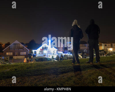 Warden Bay, Kent, Großbritannien. 8 Dez, 2017. Ein Haus in Warden Bucht setzt auf eine beeindruckende Weihnachtsbeleuchtung Anzeige mit einem Weihnachtsbaum größer als das Haus von der Beleuchtung, die eine Reihe von Computer-gesteuerte Muster gebildet. Jeden Freitag im Dezember vor Weihnachten eine kurze Anzeige auf ist für Einheimische um 19.00 Uhr, mit den Lichtern zu Musik eingestellt. Heute Abend sogar auf den außergewöhnlich kalten Abend, rund 50 Personen kam heraus zu beobachten. Die Anzeige ist von Daniel und Kelly Arnott mit Spenden aufgebracht für Nächstenliebe organisiert. Credit: James Bell/Alamy Leben Nachrichten. Stockfoto