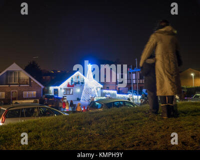 Warden Bay, Kent, Großbritannien. 8 Dez, 2017. Ein Haus in Warden Bucht setzt auf eine beeindruckende Weihnachtsbeleuchtung Anzeige mit einem Weihnachtsbaum größer als das Haus von der Beleuchtung, die eine Reihe von Computer-gesteuerte Muster gebildet. Jeden Freitag im Dezember vor Weihnachten eine kurze Anzeige auf ist für Einheimische um 19.00 Uhr, mit den Lichtern zu Musik eingestellt. Heute Abend sogar auf den außergewöhnlich kalten Abend, rund 50 Personen kam heraus zu beobachten. Die Anzeige ist von Daniel und Kelly Arnott mit Spenden aufgebracht für Nächstenliebe organisiert. Credit: James Bell/Alamy Leben Nachrichten. Stockfoto