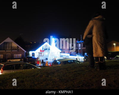 Warden Bay, Kent, Großbritannien. 8 Dez, 2017. Ein Haus in Warden Bucht setzt auf eine beeindruckende Weihnachtsbeleuchtung Anzeige mit einem Weihnachtsbaum größer als das Haus von der Beleuchtung, die eine Reihe von Computer-gesteuerte Muster gebildet. Jeden Freitag im Dezember vor Weihnachten eine kurze Anzeige auf ist für Einheimische um 19.00 Uhr, mit den Lichtern zu Musik eingestellt. Heute Abend sogar auf den außergewöhnlich kalten Abend, rund 50 Personen kam heraus zu beobachten. Die Anzeige ist von Daniel und Kelly Arnott mit Spenden aufgebracht für Nächstenliebe organisiert. Credit: James Bell/Alamy Leben Nachrichten. Stockfoto