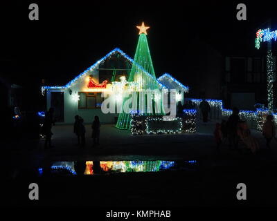 Warden Bay, Kent, Großbritannien. 8 Dez, 2017. Ein Haus in Warden Bucht setzt auf eine beeindruckende Weihnachtsbeleuchtung Anzeige mit einem Weihnachtsbaum größer als das Haus von der Beleuchtung, die eine Reihe von Computer-gesteuerte Muster gebildet. Jeden Freitag im Dezember vor Weihnachten eine kurze Anzeige auf ist für Einheimische um 19.00 Uhr, mit den Lichtern zu Musik eingestellt. Heute Abend sogar auf den außergewöhnlich kalten Abend, rund 50 Personen kam heraus zu beobachten. Die Anzeige ist von Daniel und Kelly Arnott mit Spenden aufgebracht für Nächstenliebe organisiert. Credit: James Bell/Alamy Leben Nachrichten. Stockfoto