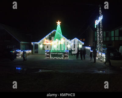 Warden Bay, Kent, Großbritannien. 8 Dez, 2017. Ein Haus in Warden Bucht setzt auf eine beeindruckende Weihnachtsbeleuchtung Anzeige mit einem Weihnachtsbaum größer als das Haus von der Beleuchtung, die eine Reihe von Computer-gesteuerte Muster gebildet. Jeden Freitag im Dezember vor Weihnachten eine kurze Anzeige auf ist für Einheimische um 19.00 Uhr, mit den Lichtern zu Musik eingestellt. Heute Abend sogar auf den außergewöhnlich kalten Abend, rund 50 Personen kam heraus zu beobachten. Die Anzeige ist von Daniel und Kelly Arnott mit Spenden aufgebracht für Nächstenliebe organisiert. Credit: James Bell/Alamy Leben Nachrichten. Stockfoto