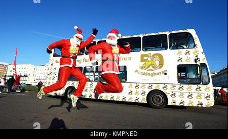 Brighton, UK. 9. Dezember 2017. Santas Sprung in Aktion als Hunderte nehmen teil an der Brighton Santa Strich heute entlang der Küste von Brighton und Hove Geld für die lokale Rockinghorse Nächstenliebe Foto von Simon Dack/Alamy Leben Nachrichten genommen Stockfoto