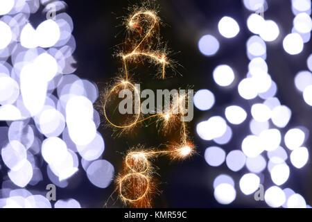Isolierte 2018 Zeichen mit Schein Feuerwerk auf schwarzem Hintergrund mit unscharfen Dekoration leuchten, glückliches neues Jahr 2018 Konzept geschrieben. Stockfoto