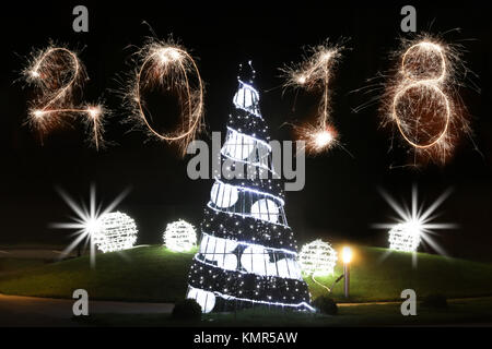 Isolierte 2018 Zeichen mit Schein Feuerwerk mit geschmückten Weihnachtsbaum geschrieben, neues Jahr 2018 Konzept zufrieden. Stockfoto