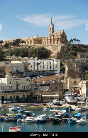 Den Hafen und Fähranleger in Mgarr auf Gozo übersicht Gebäude anda Kirche auf die Stadt und die Boote im Hafen Stockfoto