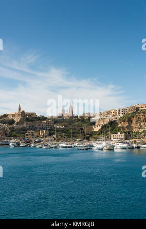 Den Hafen und Fähranleger in Mgarr auf Gozo übersicht Gebäude anda Kirche auf die Stadt und die Boote im Hafen Stockfoto