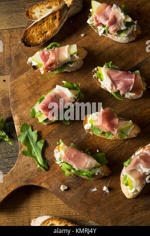 Hausgemachten Schinken Birne Käse Crostini mit Rucola Stockfoto