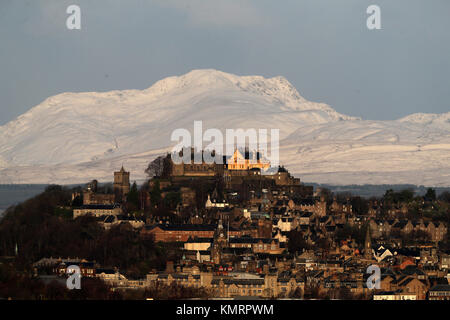 Blick auf die Burg Stirling am frühen Morgen Sonnenschein mit den schneebedeckten Stuc ein 'Chroin Berg im Hintergrund. Stockfoto