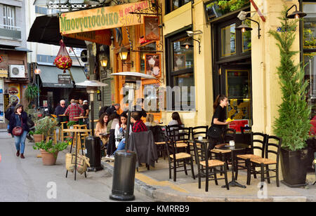 Zwei Restaurants, beide mit Tischen und Stühlen auf Pflaster außen mit Kunden, Athen, Griechenland. Stockfoto