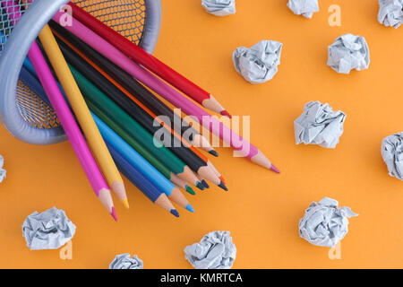 Buntstifte in einem Behälter mit zerknittertem Papier Kugeln in der Nähe von ihnen. Close Up. Stockfoto