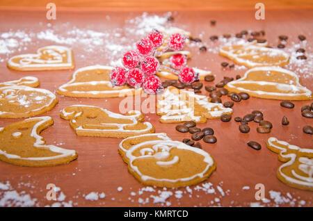 Weihnachten Lebkuchen mit weißer Glasur, Kaffeebohnen und Rowan Zweig für die Dekoration auf einem Holzbrett Stockfoto