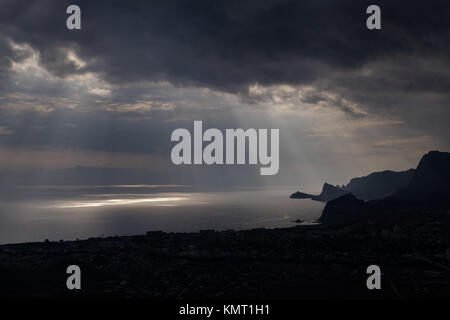 Unheilvolle Wolken und dem Platzen Lichtstrahlen über den Golf Meer Stockfoto