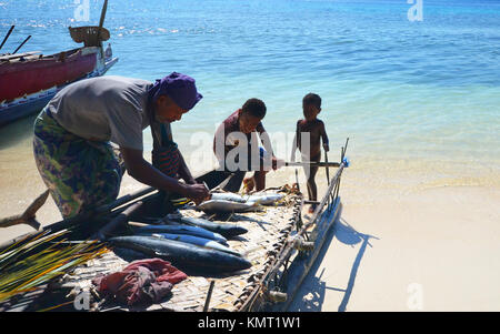 Vater und seine Söhne mit fangfrischem Fisch auf Fischerboot Stockfoto