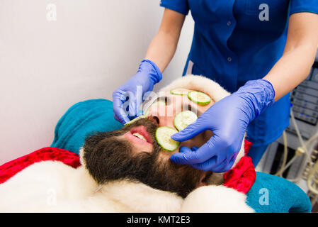 Santa Claus mit Gurke Gesichtsmaske im Beauty Spa Stockfoto