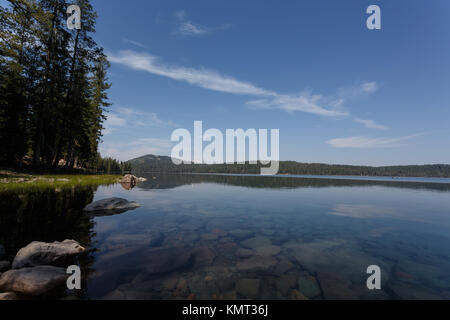 Ruhiges klares Wasser zeigen Felsen unter Wasser entlang der Küstenlinie von einem Alpinen See in den Lassen Volcanic National Park an einem sonnigen Tag Stockfoto