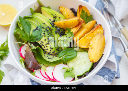 Buddha rainbow Schüssel Salat mit gebackenen Kartoffeln, Avocado, Radieschen und Gurken. Vegan Gesunde Ernährung Konzept. Stockfoto