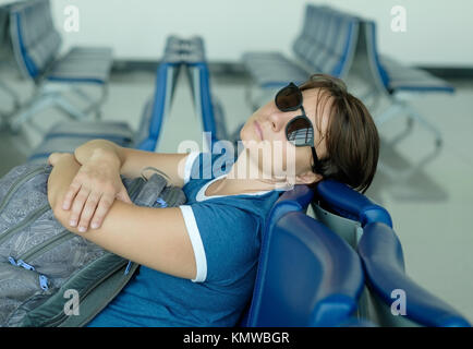 Müde kaukasische Frau schlafen in der Lounge warten auf Flug Stockfoto