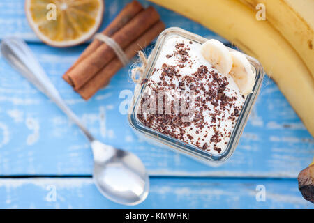 Cremiger Milchreis mit Banane, Schokolade und Zimt zum Frühstück. Stockfoto