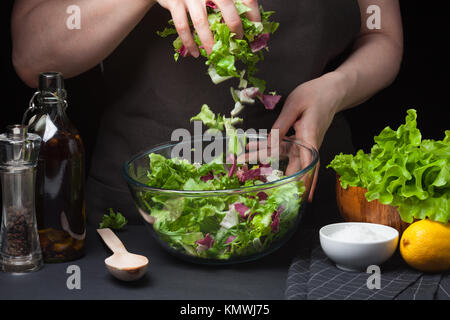 Frau Koch in der Küche kochen Gemüse Salat. Das gesunde Essen. Diät Konzept. Eine gesunde Lebensweise. Zu Hause kochen. Um das Essen vorzubereiten. Mädchen mischen Stockfoto