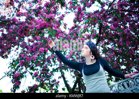 Portrait einer jungen schönen Mädchen in einem blühenden Baum. Schönheit der Frühling ohne Allergie. Stockfoto