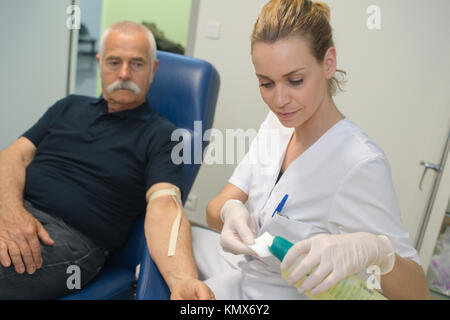 Ältere Menschen und Krankenschwester Kontrolle der Blutzuckerspiegel Stockfoto