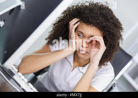 Junge Geschäftsfrau in Kopfschmerzen Stress am Arbeitsplatz Stockfoto