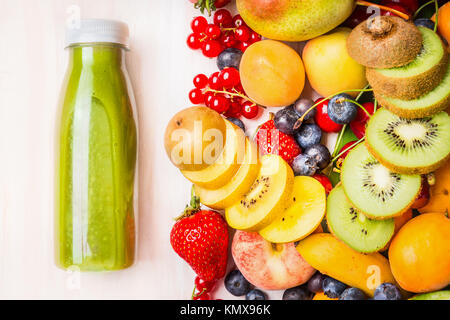 Grüne Smoothie oder Saft mit verschiedenen Früchten und Beeren Zutaten auf weißem Holz- Hintergrund, Ansicht von oben Stockfoto