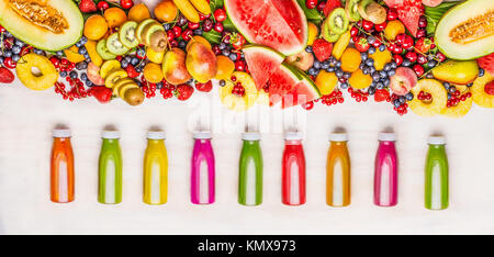 Vielfalt von bunten Smoothies und Säfte Getränke in Flaschen mit verschiedenen frischen biologischen Früchten und Beeren Zutaten auf weißem Hintergrund, aus Holz Stockfoto