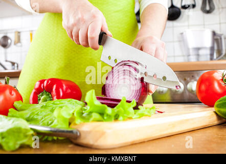 Weibes Hände schneiden Zwiebel Zwiebel, hinter frisches Gemüse. Stockfoto