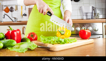 Frauenhand schneiden frische Paprika in der Küche Stockfoto