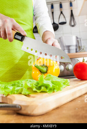 Frauenhand schneiden frische Paprika in der Küche Stockfoto