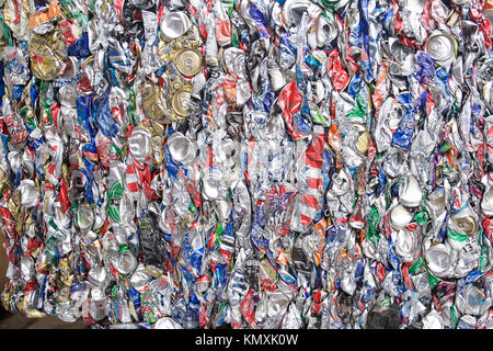 Recycling Center mit Ballen von Metall- und Kran mit Greifer werfen Lkw und rostige Räder Stockfoto