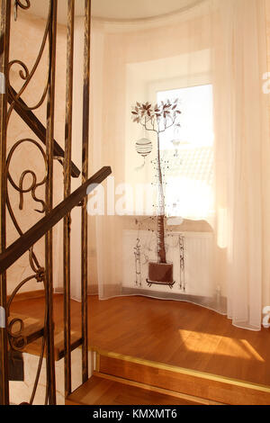 Blick auf ein Fenster mit einem schönen Vorhang von einer Leiter, eine vertikale Shot Stockfoto