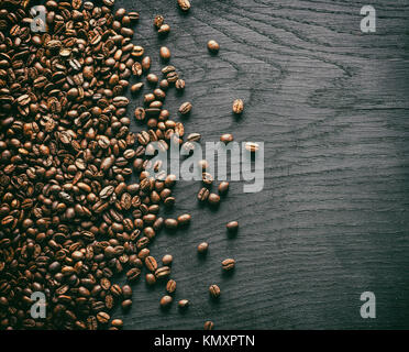 Geröstete Kaffeebohnen auf dem alten Holz- Hintergrund. Ansicht von oben. Stockfoto