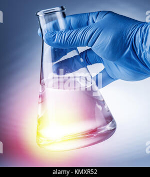 Labor-Becher in der Hand des Analytikers in Kunststoff-Handschuh. Stockfoto