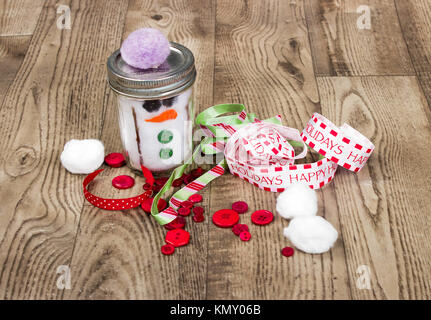 Weihnachten Hintergrund mit Bändern, hausgemachte Schneemann jar, Buttons und anderes Kunsthandwerk Stockfoto