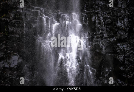 Eine heftige Wasserfall markanten schwarzen Vulkangestein. Stockfoto