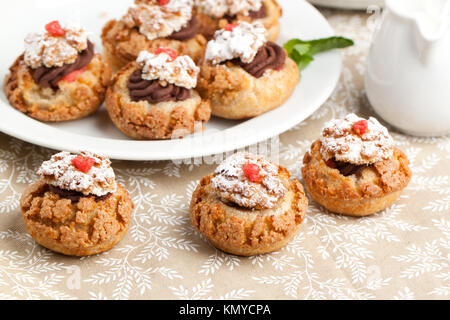 Mini Kuchen mit Mousse au Chocolat auf Tischdecke serviert. Stockfoto