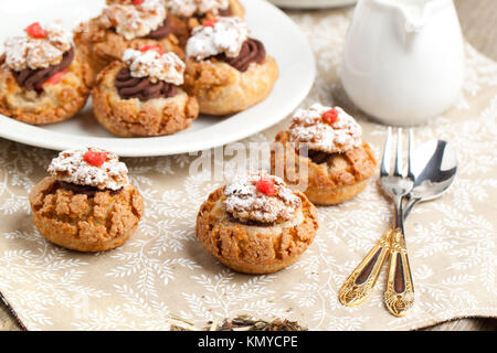 Mini Kuchen mit Mousse au Chocolat auf Tischdecke mit Besteck serviert. Stockfoto