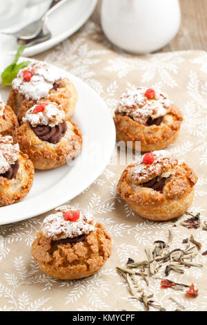 Mini Kuchen mit Mousse au Chocolat auf Tischdecke serviert. Siehe Serie Stockfoto