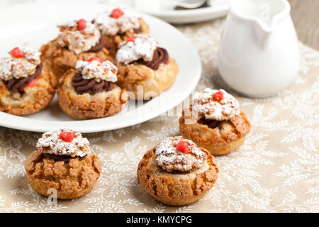 Mini Kuchen mit Mousse au Chocolat auf Tischdecke serviert. Stockfoto