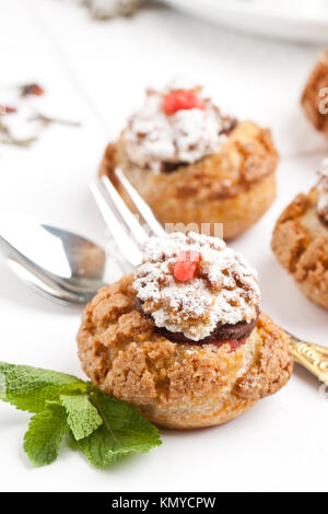 Mini Kuchen mit Schokoladenmousse serviert mit Minze und Besteck über Weiß Stockfoto