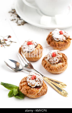 Mini Kuchen mit Schokoladenmousse serviert mit Minze und Besteck über Weiß Stockfoto